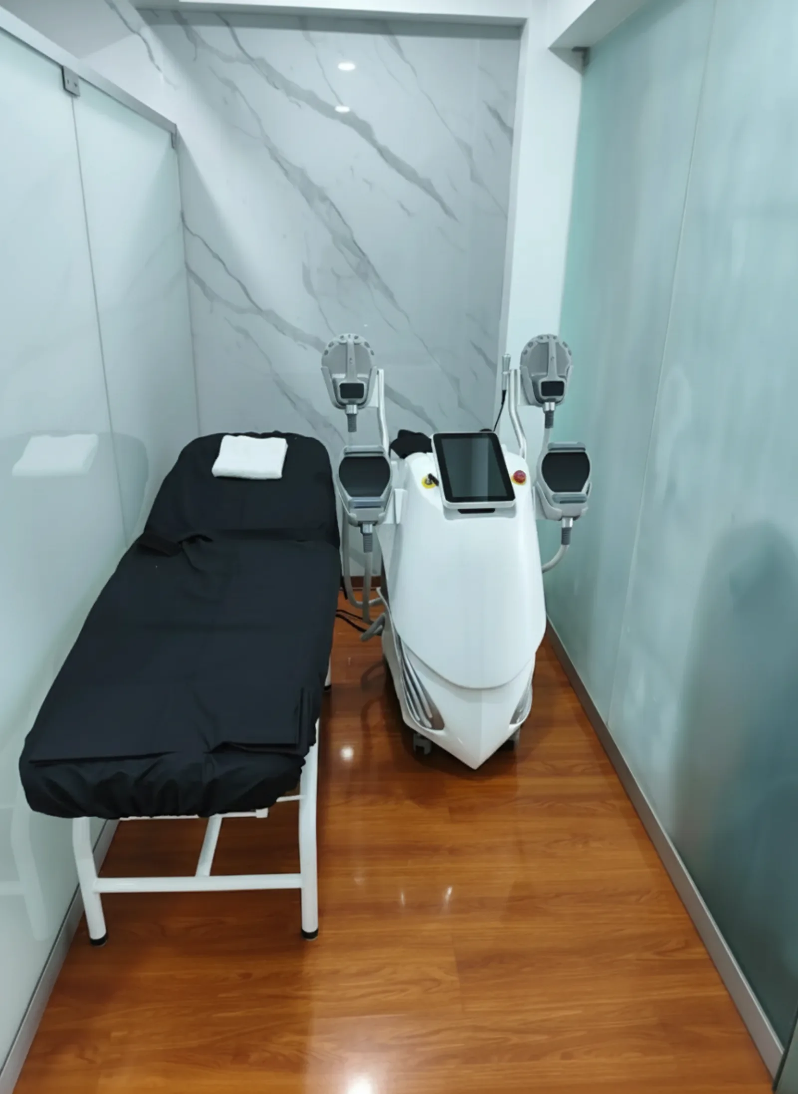 Sala de EMSculpt en Elyzea con equipo de tonificación muscular electromagnética y camilla de terapia